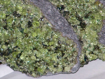 Minerál olivín (zelený) v čediči, foto Vsmith [CC BY-SA (http://creativecommons.org/licenses/by-sa/3.0/)].