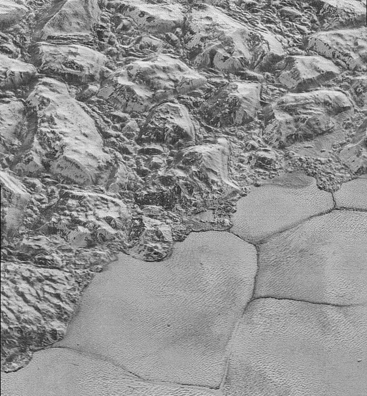 Duny na povrchu planety Pluto ve spodní polovině obrázku v oblasti zvané Sputnik Planitia. Horský hřeben pokrývá horní polovinu obrázku, jehož šířka činí 75 km. NASA/Johns Hopkins University Applied Physics Laboratory/Southwest Research Institute.