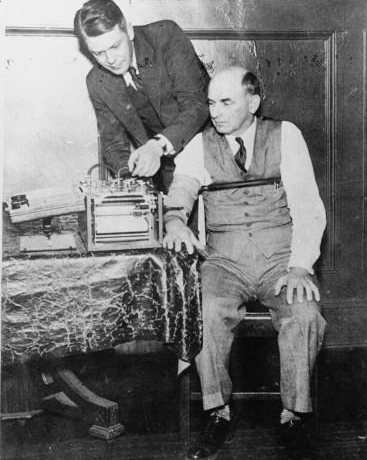 Původní detektor lži při práci v roce 1937 (Agence de presse Meurisse, Public domain, via Wikimedia Commons). Jeden z tvůrců detektoru Leonarde Keeler (1903-1949) testuje Dr.Kohlera, svědka v případu Bruno Hauptmana, únosce a vraha syna amerického  letce Charlese Lindbergha.