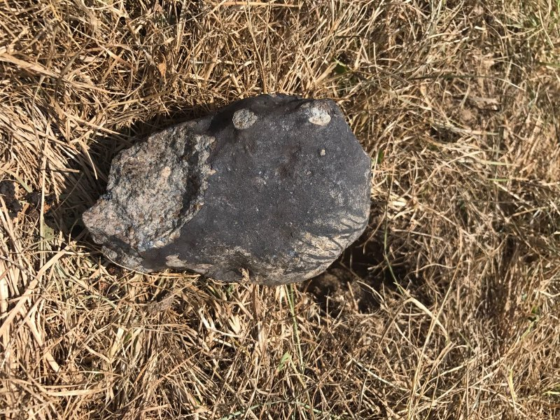 Největší úlomek meteoritu Renchen označený M2 nalezený dne 31. července 2018. Vpravo od něj vidíme i jamku vzniklou dopadem. Foto: Ralph Sporn a Martin Neuhofer via Tisková zpráva Astronomického ústavu AV ČR.